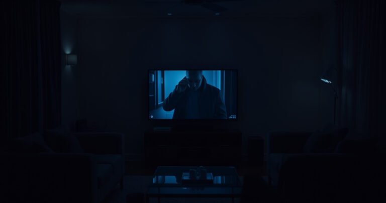 A dimly lit living room with a glowing smart TV screen displaying a distorted reflection of a shadowy figure peering in, surrounded by modern furniture. The atmosphere is tense, with flickering lights casting eerie shadows, and a sense of unease hangs in the air, inviting curiosity and suspicion about privacy in the digital age.