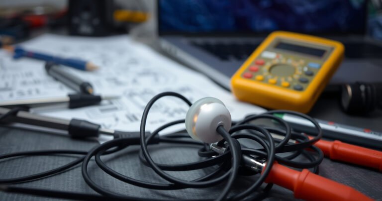 A close-up of a tangled pair of earphones, with one earbud glowing faintly, surrounded by scattered tools like tweezers and a multimeter. The background features a blurred tech workspace with circuit diagrams and a laptop, emphasizing a mix of frustration and curiosity, inviting viewers to explore the mystery of malfunctioning audio devices.