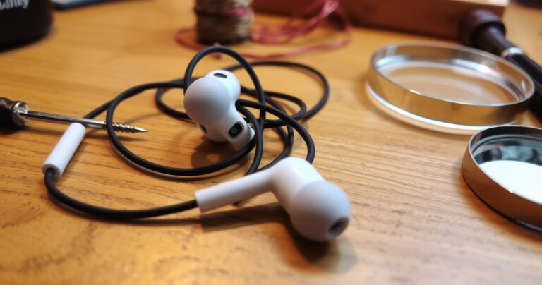 A close-up view of a pair of tangled earbuds on a wooden table, one earbud glowing faintly to indicate sound, while the other lies dull and silent. Surrounding them are tools like a tiny screwdriver, a spool of wire, and a magnifying glass, suggesting a hands-on repair process in a cozy, inviting workspace.